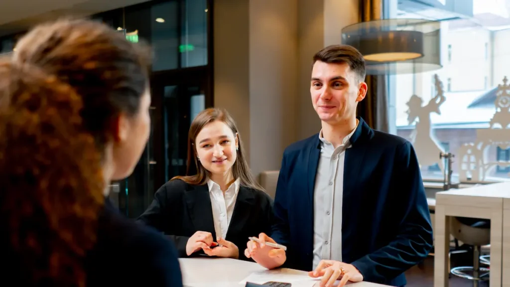 receptionist at a counter meets guests